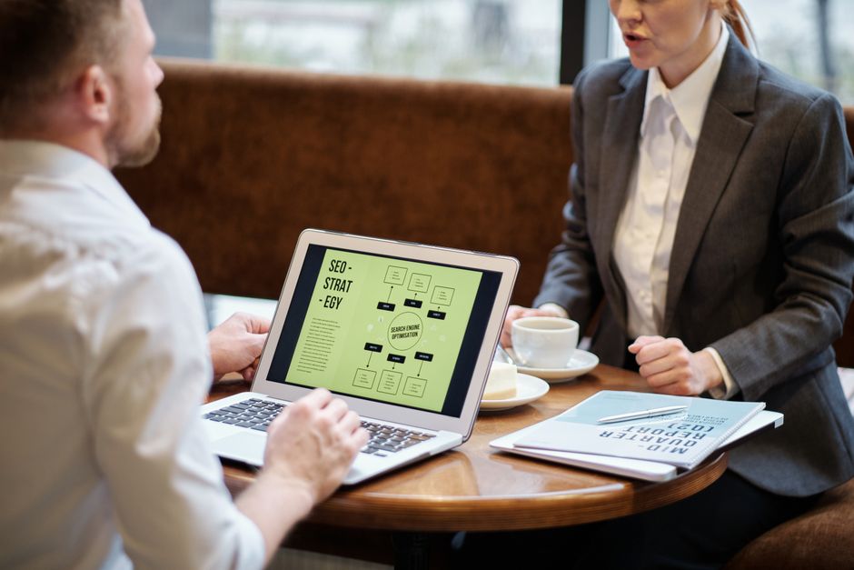 Reunión de negocios discutiendo estrategia SEO en una cafetería